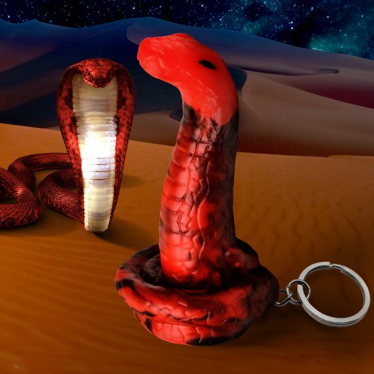 A mini King Cobra snake keychain in red and black silicone, designed for novelty use, depicting a playful and seductive fantasy accessory, showcased on a neutral background.