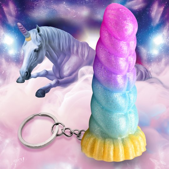 Pastel colored unicorn horn keychain made of phthalate-free silicone and nickel-free metal, featuring vibrant blue, purple, and orange colors, displayed against a whimsical forest background.