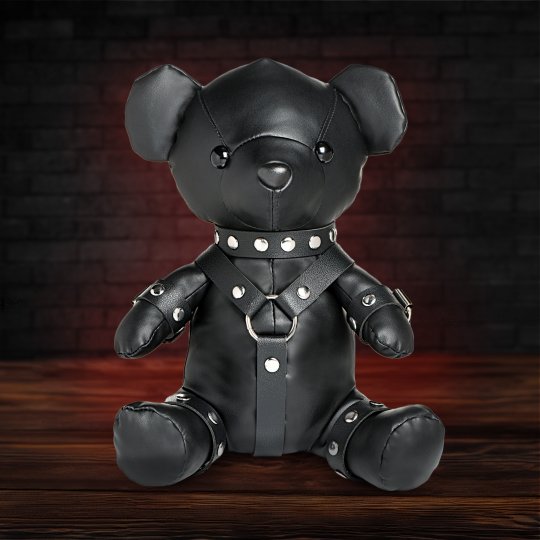 A 10.5-inch teddy bear dressed in a detailed gimp outfit made of black vegan leather, showcasing a playful and edgy aesthetic, suitable for adding a quirky touch to a collection or as a cuddly companion.