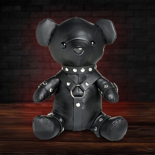 A 10.5-inch teddy bear dressed in a detailed gimp outfit made of black vegan leather, showcasing a playful and edgy aesthetic, suitable for adding a quirky touch to a collection or as a cuddly companion.