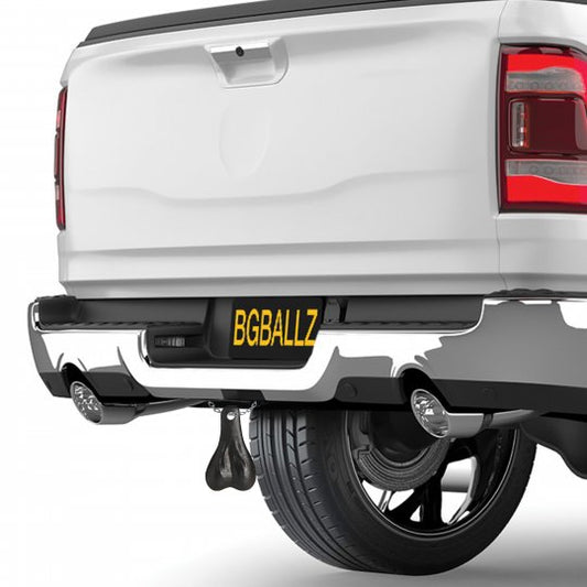 A set of Big Truck Nuts hanging from a trailer hitch, showcasing their humorous design in black plastic, perfect for adding playful decor to any vehicle.