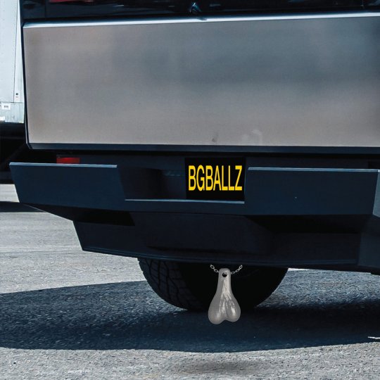 Fake truck balls hanging from a car hitch, silver color, plastic material, 7.5 inches long, 4.3 inches wide, 2.2 inches high, used as a humorous gag gift for bachelor parties and birthday celebrations.