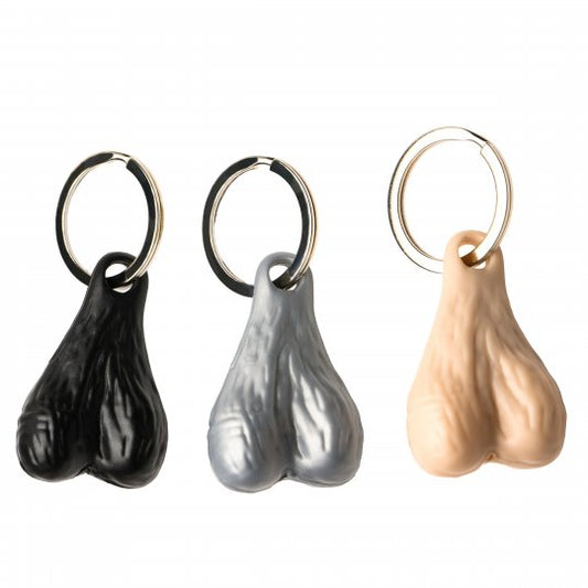 Big Nuts Keychain featuring oversized plastic testicles attached to a nickel-free metal ring, available in black, light, and silver colors, displayed against a white background.