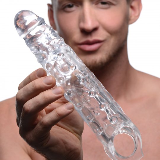 Image of a penis enhancing sleeve designed to wrap around the penis and scrotum, showcasing its realistic texture with prominent veins and a bold tip, highlighting its dimensions and compatibility with lubricants.