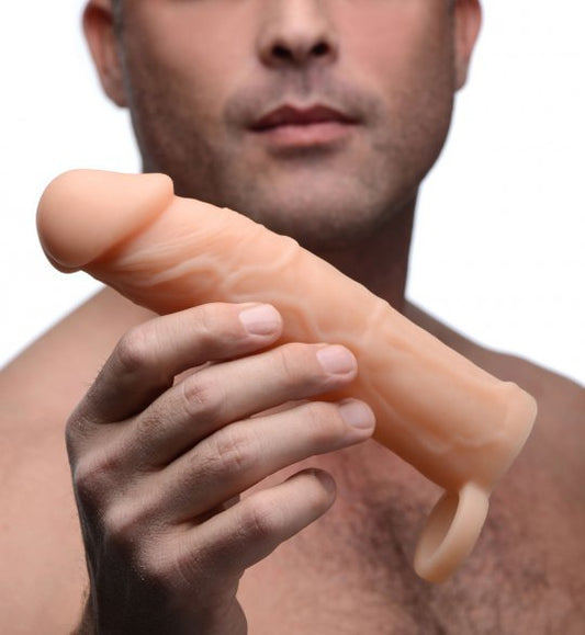 Premium silicone erection enhancer with a realistic design, featuring bulging veins and a bold head, measuring 7 inches in total length with a 5-inch insertable length and 2-inch additional extension length, in flesh color.